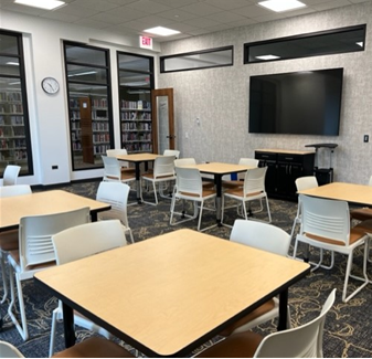 Six square tables & chairs. Floor has carpeting.