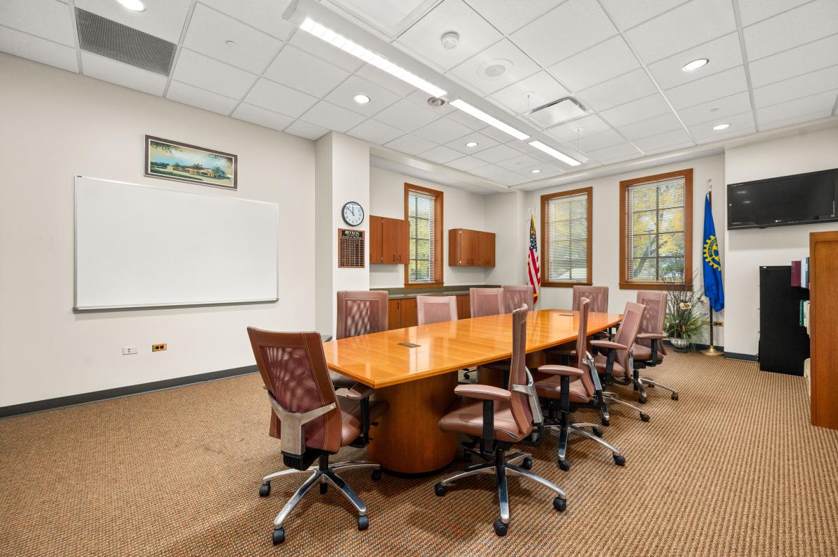 Room has a large wood table and comfortable chairs.